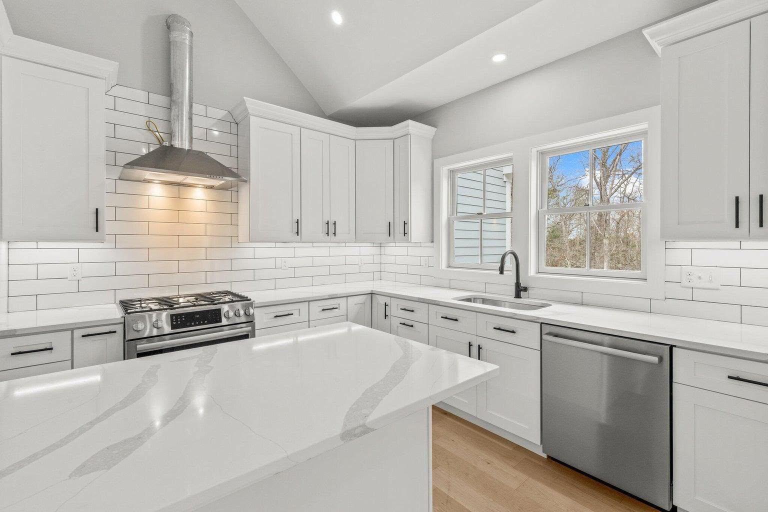 Custom white kitchen cabinetry with quartz island